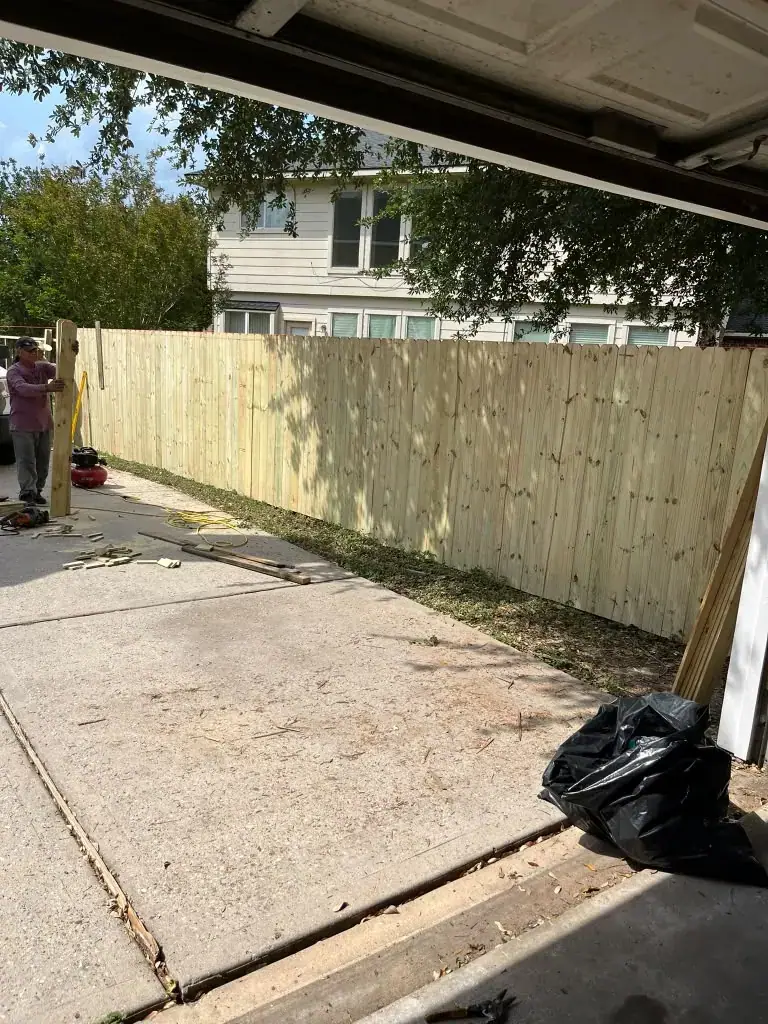 Tramo de cerca de madera en un patio abierto.