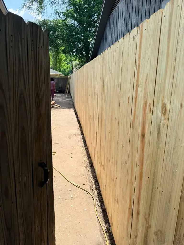 Cerca de madera junto a una puerta exterior.